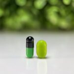 Venlafaxine compounded capsule for dogs and cats shown next to a green Tic Tac for size comparison.